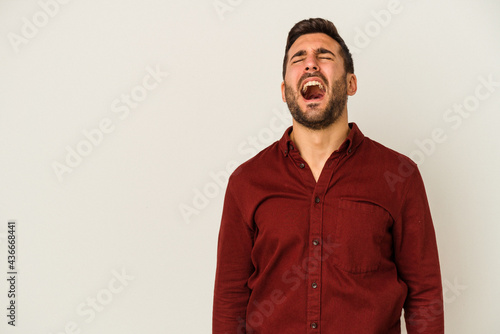 Young caucasian man isolated on white background shouting very angry, rage concept, frustrated.