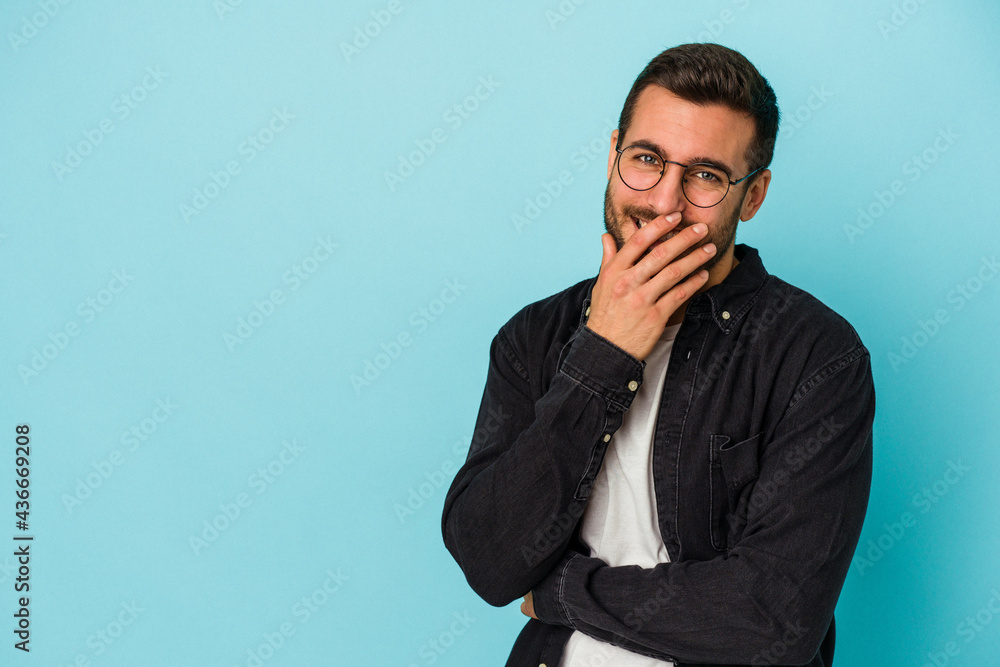 Young caucasian man isolated on blue background laughing happy, carefree, natural emotion. Young caucasian man isolated on blue background laughing happy, carefree, natural emotion.