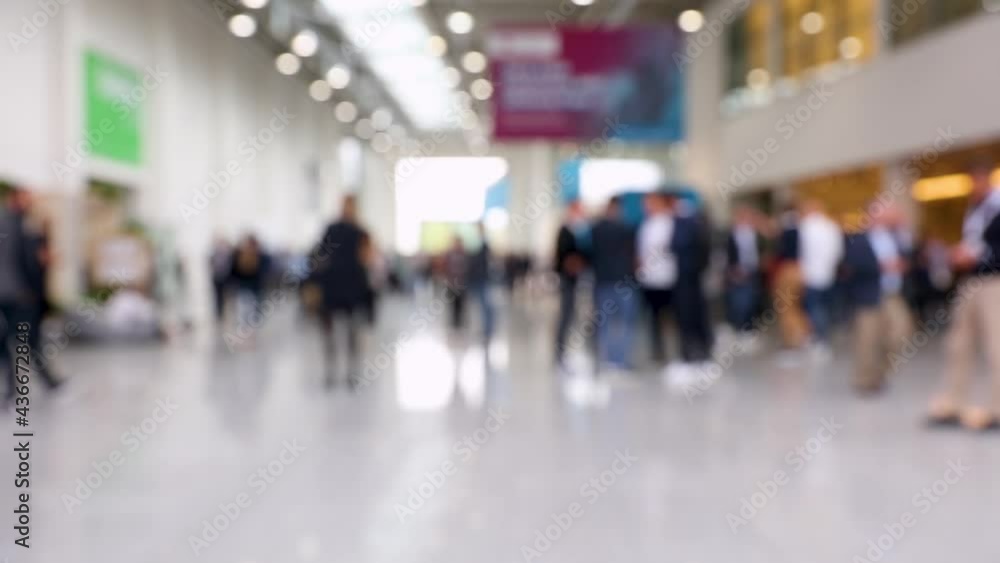 Blurred crowd of people walking around conference hall Blurred crowd of people walking around conference hall