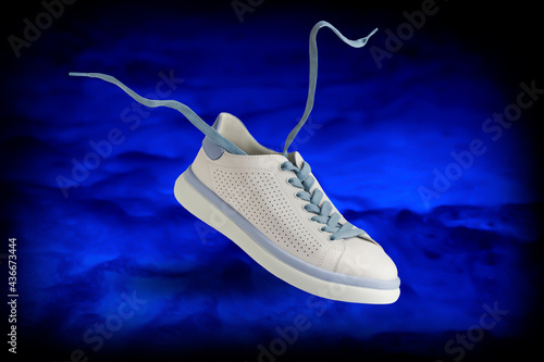 Sports shoes with laces. Levitation sneaker on a bright blue background.