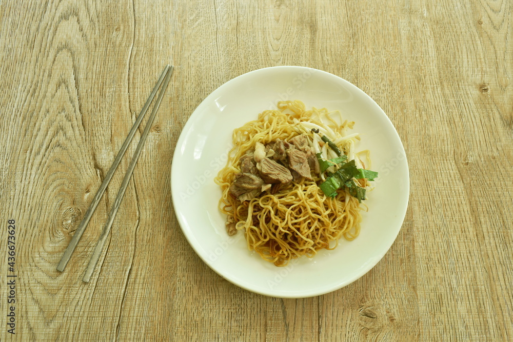 Chinese yellow egg noodles topping braised pork on plate Chinese yellow egg noodles topping braised pork on plate