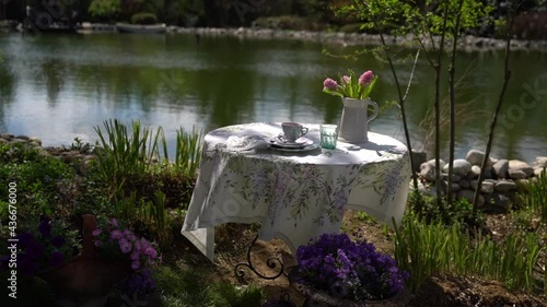 Table set with floral print tablecloth, with flowers on the table