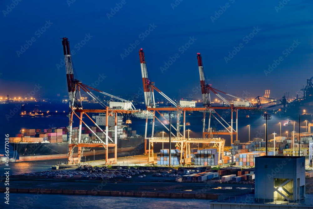 夜の川崎工業地帯と港の巨大なクレーン