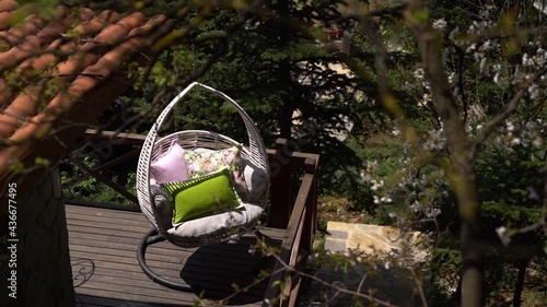 Swing chair by the lake with beautiful decorative pillows.