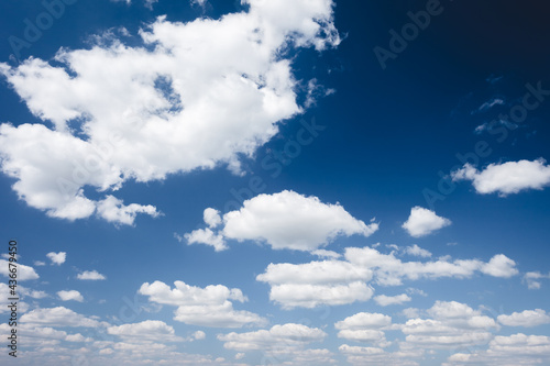 Idyllic blue sky with white fluffy clouds in sunny day.
