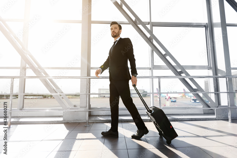 Side view of businessman standing next to window at airport Side view of businessman standing next to window at airport