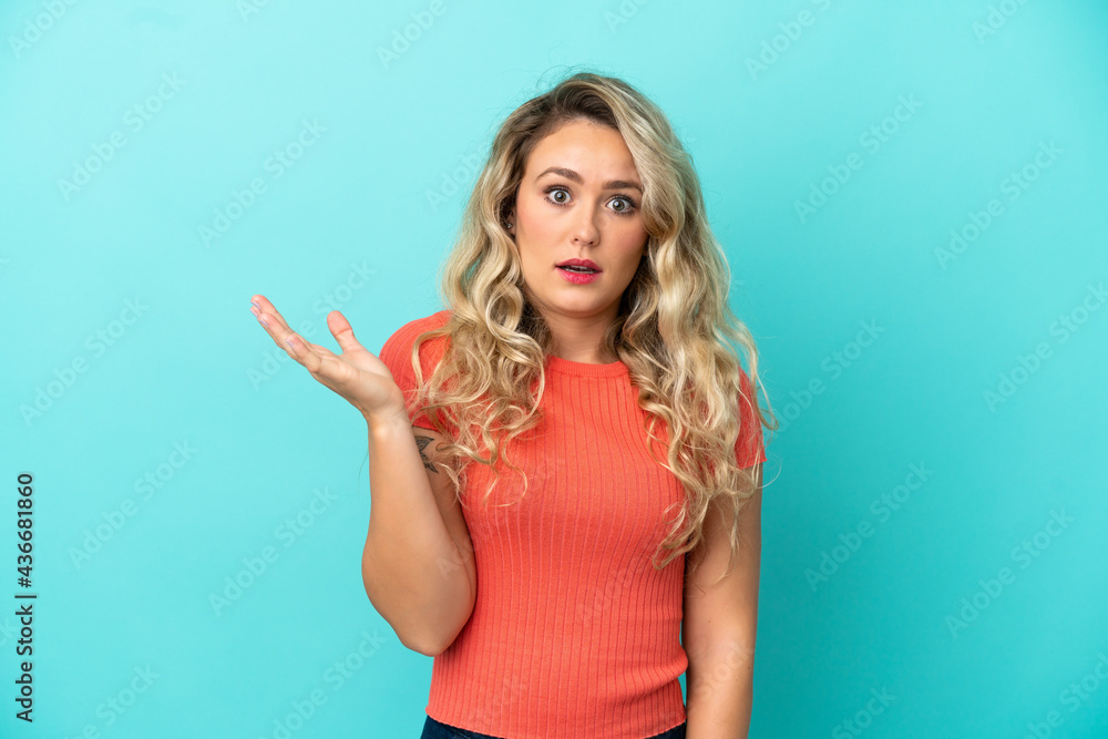 Young Brazilian woman isolated on blue background making doubts gesture Young Brazilian woman isolated on blue background making doubts gesture