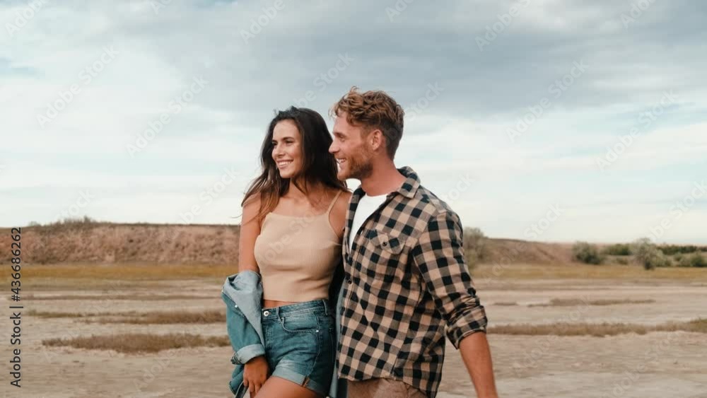 Lovely couple boyfriend and girlfriend are walking together on the nature Lovely couple boyfriend and girlfriend are walking together on the nature