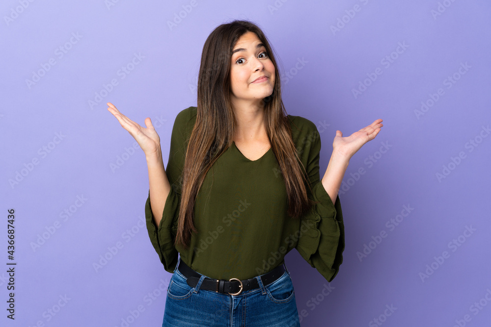 Teenager Brazilian girl over isolated purple background making doubts gesture Teenager Brazilian girl over isolated purple background making doubts gesture