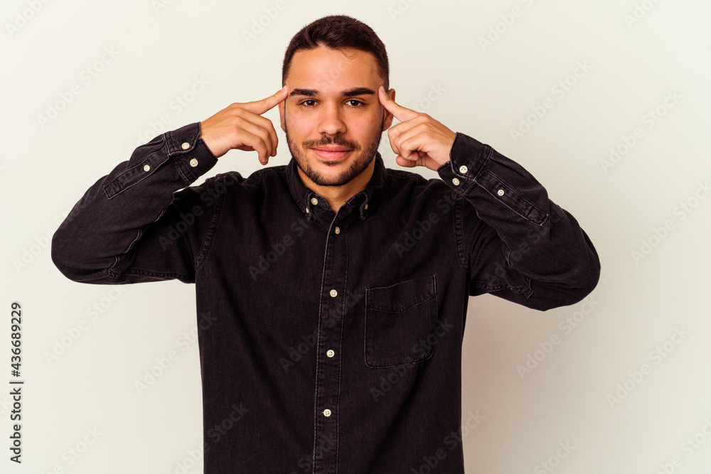Young caucasian man isolated on white background focused on a task, keeping forefingers pointing head. Young caucasian man isolated on white background focused on a task, keeping forefingers pointing head.