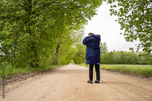 Man in black pants on a blue plait stands on the road