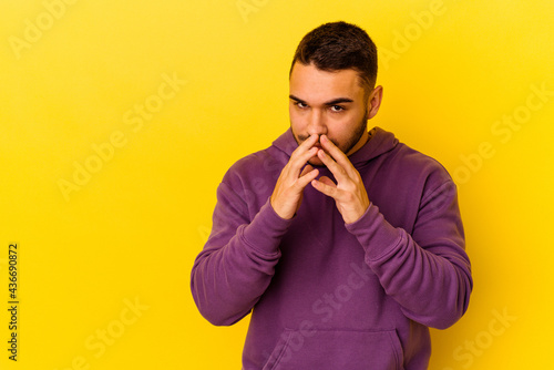 Young caucasian man isolated on yellow background making up plan in mind, setting up an idea.
