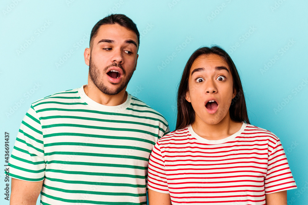 Young mixed race couple isolated on blue background Young mixed race couple isolated on blue background