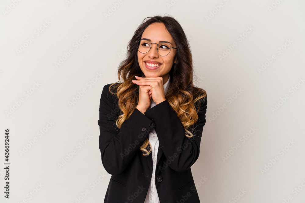 Young mexican business woman isolated on white background keeps hands under chin, is looking happily aside. Young mexican business woman isolated on white background keeps hands under chin, is looking happily aside.