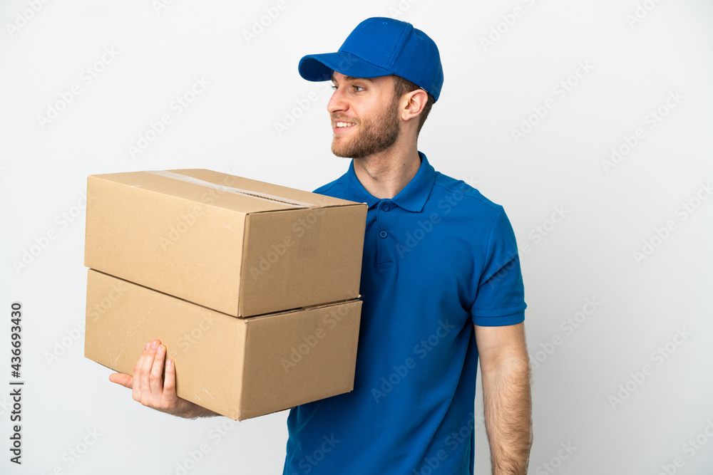 Delivery man over isolated white background looking side Delivery man over isolated white background looking side