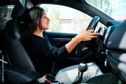 young latin woman driving luxury car