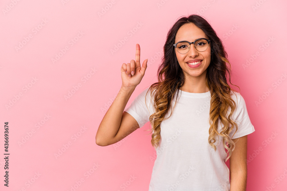 Φωτογραφία Young mexican woman isolated on pink background showing number one with finger