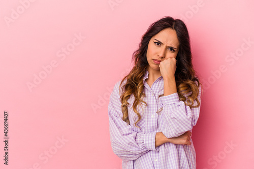 Young mexican woman isolated on pink background who feels sad and pensive, looking at copy space. © Asier