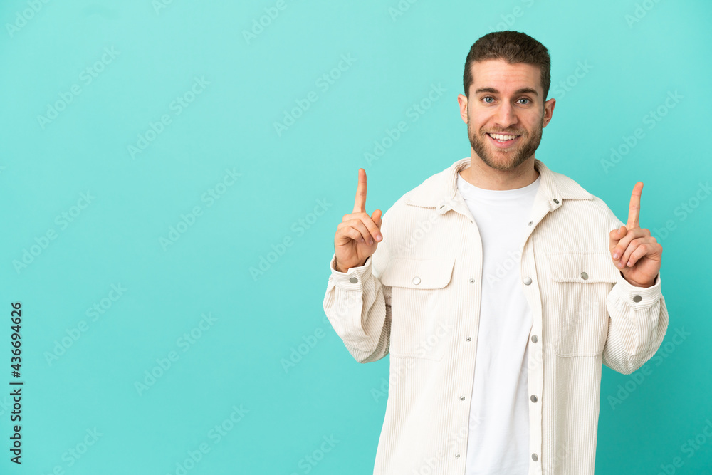 Handsome blonde man over isolated blue background pointing up a great idea Handsome blonde man over isolated blue background pointing up a great idea