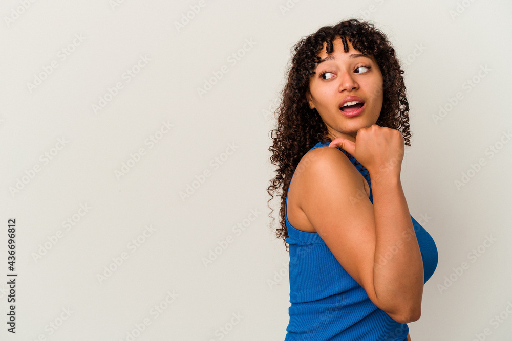 Young mixed race woman isolated on white background points with thumb finger away, laughing and carefree. Young mixed race woman isolated on white background points with thumb finger away, laughing and carefree.