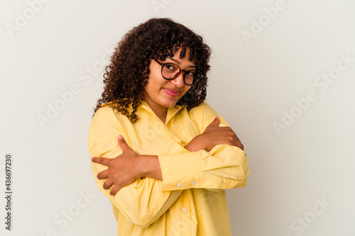 Young mixed race woman isolated on white background hugs, smiling carefree and happy. © Asier