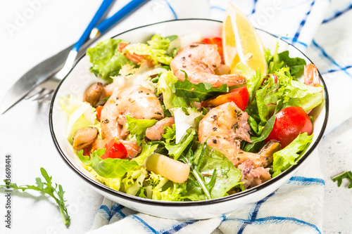 Seafood salad with fresh leaves tomatoes and fried seafood. Mediterranean diet.