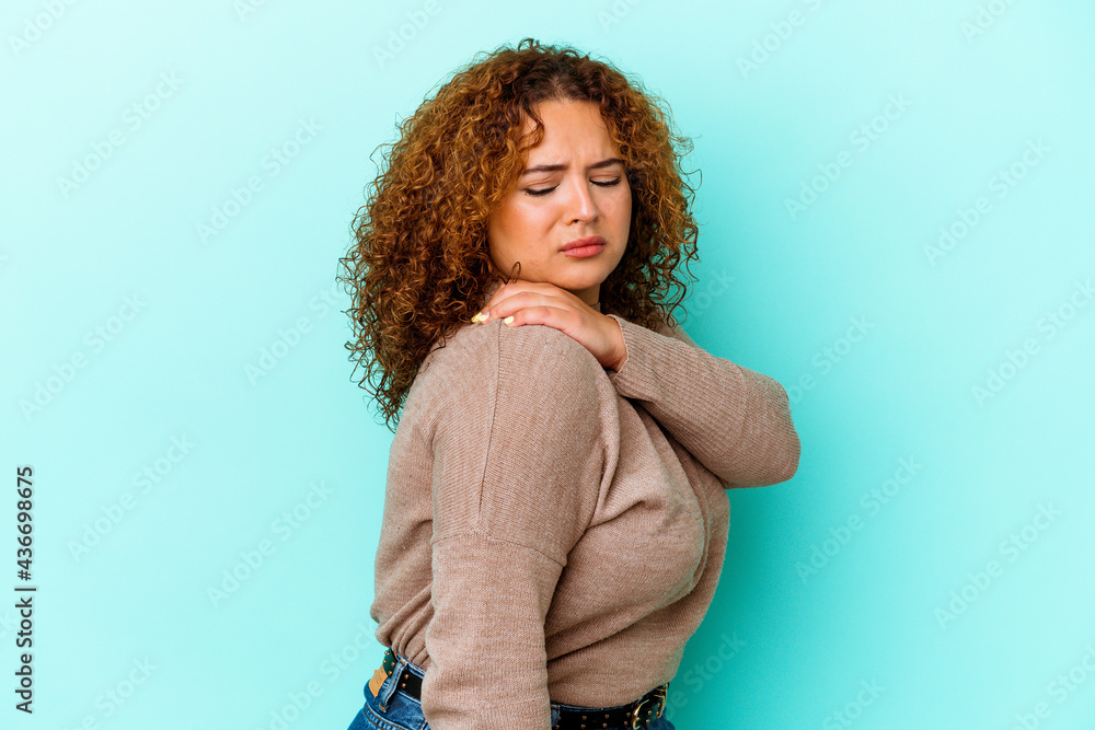 Young latin curvy woman isolated on blue background having a shoulder pain. Young latin curvy woman isolated on blue background having a shoulder pain.