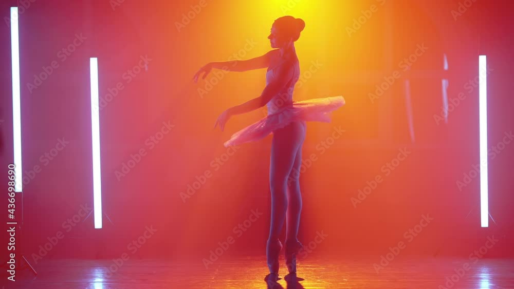Ballerina is practicing elements in studio with warm colorful light. Young woman dancing in classic tutu dress. Gracefulness and tenderness in every movement. Ballerina is practicing elements in studio with warm colorful light. Young woman dancing in classic tutu dress. Gracefulness and tenderness in every movement.