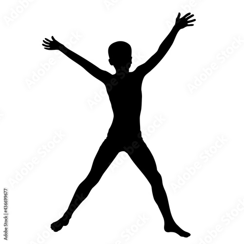 Boy jumps with his arms and legs apart, black silhouette