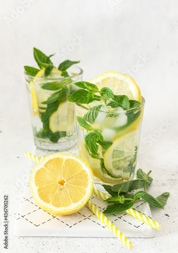 Two glass with lemonade or mojito cocktail with lemon and mint.