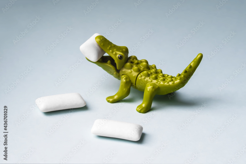 Naklejka premium Green Toy crocodile eats chewing gum pads.