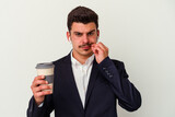 Young business caucasian man wearing wireless headphones and holding take way coffee isolated on white background with fingers on lips keeping a secret.