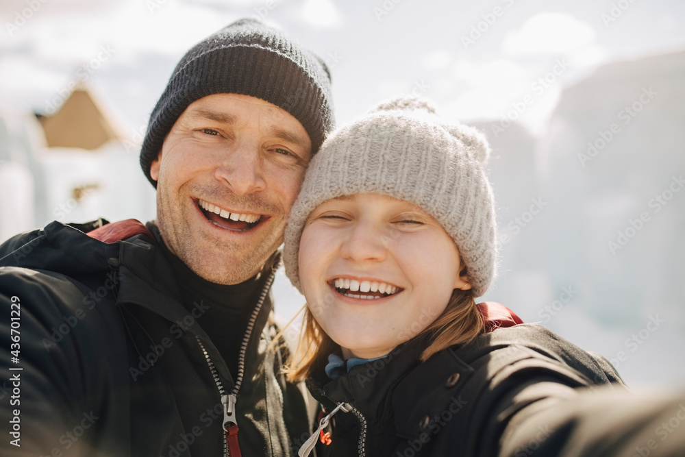 Cheerful father and daughter wearing knit hats during winter Cheerful father and daughter wearing knit hats during winter
