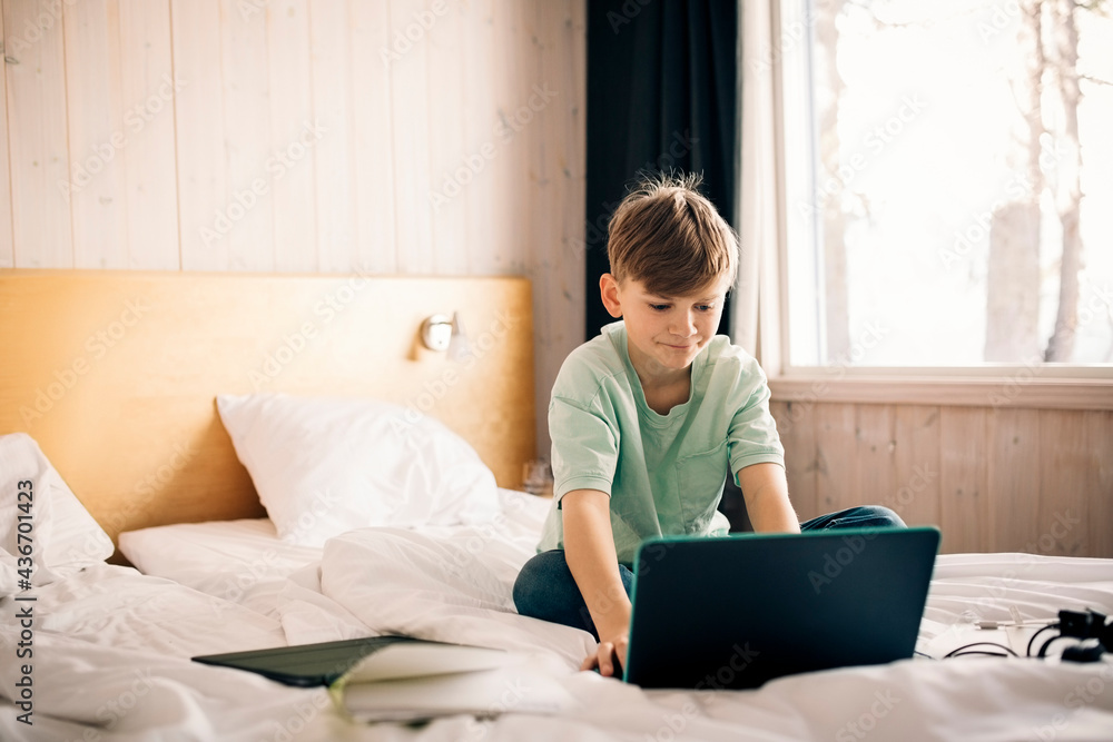 Boy using laptop while studying at home Boy using laptop while studying at home
