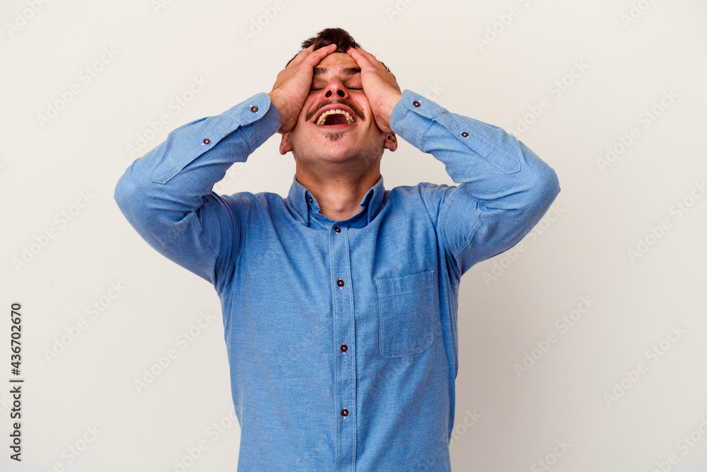 Young caucasian man isolated on white background laughs joyfully keeping hands on head. Happiness concept. Young caucasian man isolated on white background laughs joyfully keeping hands on head. Happiness concept.