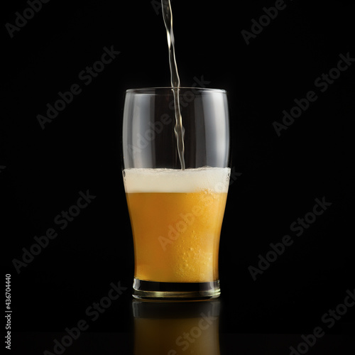 Light draft cold beer pour in glass from crane in pub. Minimalistic ad