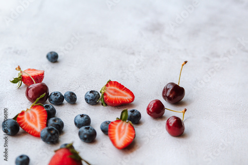 Blueberry, strawberry and cherry on light background