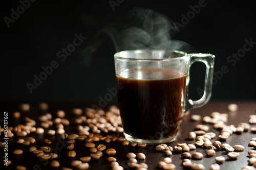 a cup of boiling coffee on a black wooden table. High quality photo