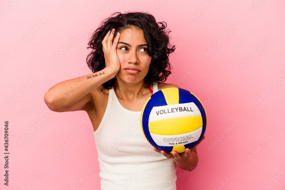 Young latin woman holding a volley ball isolated on pink background being shocked, she has remembered important meeting.