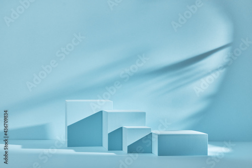 Blue background for product presentation with shadows and light. Empty podiums. Mockup.