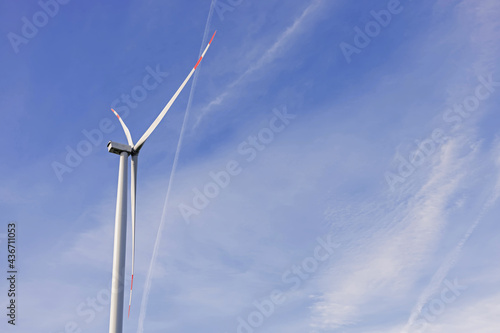 Windmill for electric power production against the blue sky.