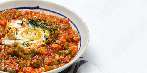 Vegetable dish pisto manchego made of tomatoes, zucchini, peppers, onions with fried egg