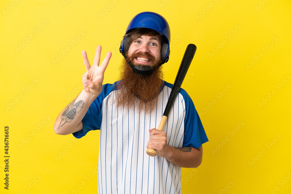 Redhead baseball player man with helmet and bat isolated on yellow background happy and counting three with fingers Redhead baseball player man with helmet and bat isolated on yellow background happy and counting three with fingers