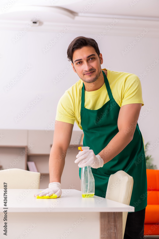 Young male contractor cleaning the house indoors Young male contractor cleaning the house indoors