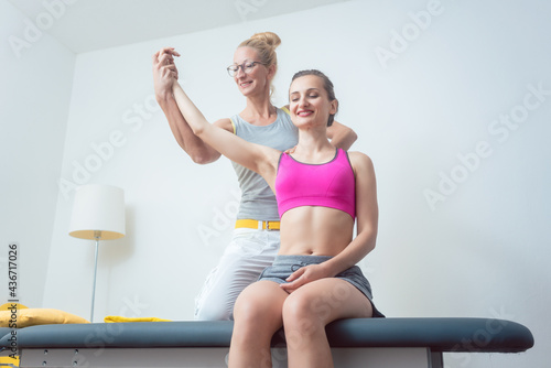 Physical therapist mobilizing arm of woman