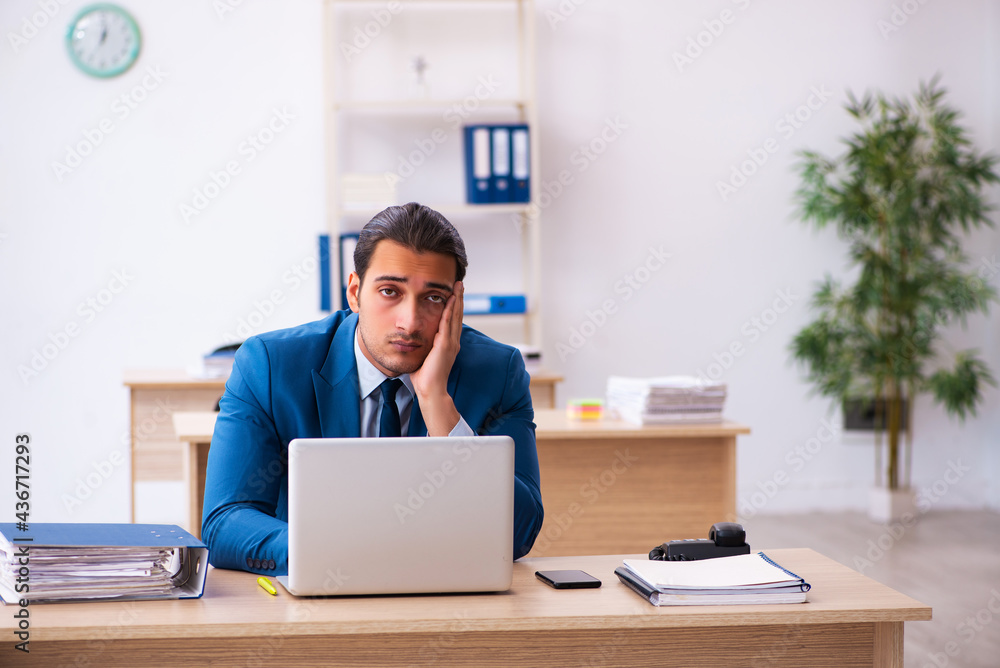 Young businessman employee unhappy with excessive work in the of Young businessman employee unhappy with excessive work in the of