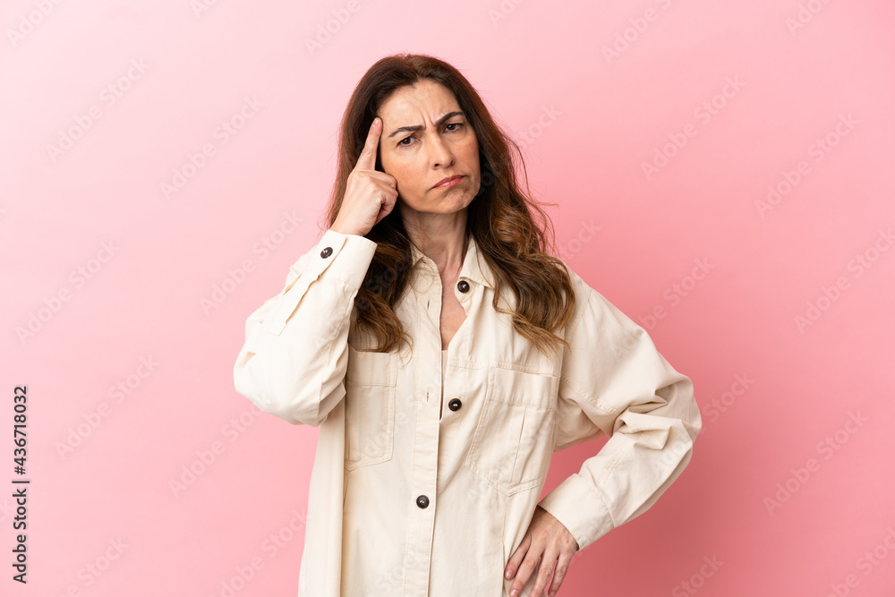 Middle aged caucasian woman isolated on pink background thinking an idea Middle aged caucasian woman isolated on pink background thinking an idea
