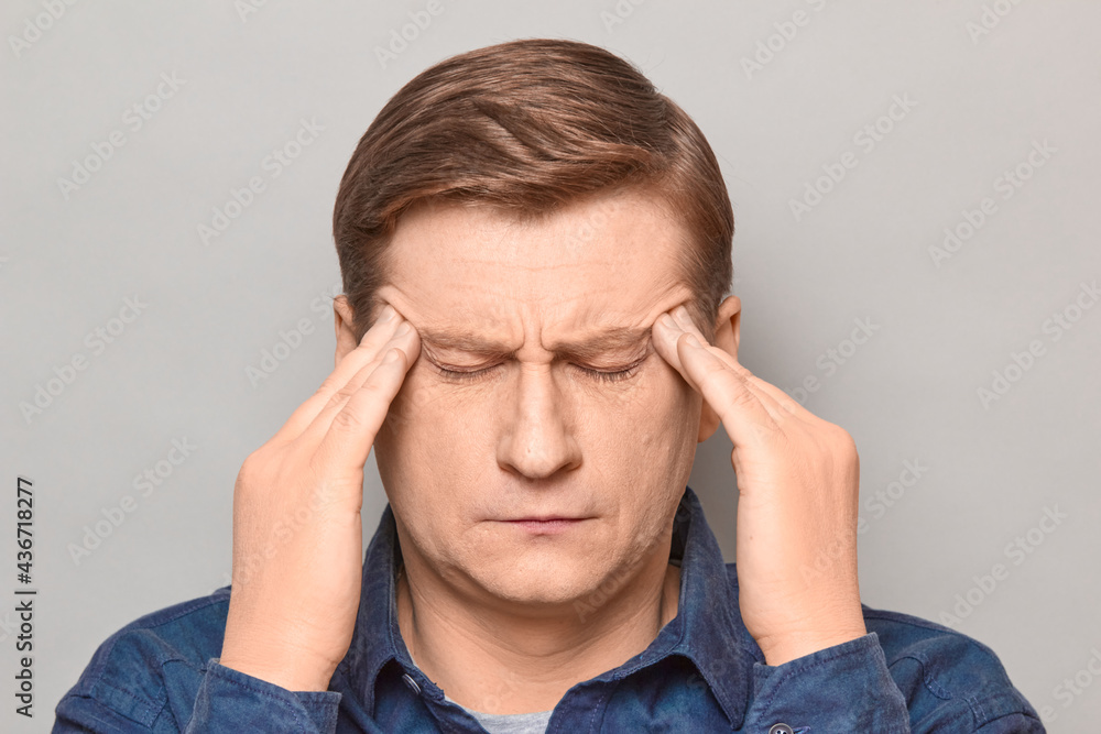Portrait of thoughtful tired man touching temples with hands Portrait of thoughtful tired man touching temples with hands