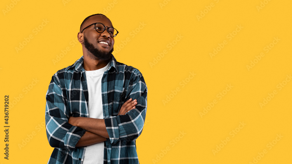 Black Man Posing Crossing Hands Looking Aside On Yellow Background Black Man Posing Crossing Hands Looking Aside On Yellow Background