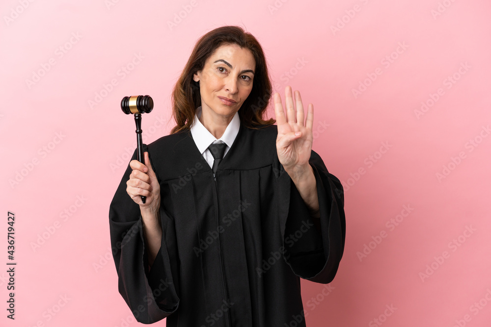 Middle aged judge woman isolated on pink background happy and counting four with fingers Middle aged judge woman isolated on pink background happy and counting four with fingers